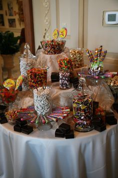 a table topped with lots of candy and candies on top of a white table cloth