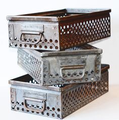 two metal boxes are stacked on top of each other with holes in the bottom and sides