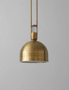 a brass pendant light hanging from the ceiling