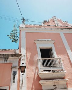 an old pink building with balcony and balconies