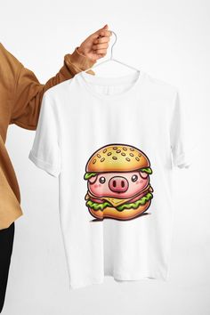 Embrace your fun side with our Pig Burger T-Shirt, the ultimate conversation piece for anyone with a taste for whimsy in their wardrobe. Ideal for foodies and novelty fashion lovers alike, this graphic tee is as comfortable as it is eye-catching. Showcasing a playful pig burger design, it's a quirky addition to your casual wear or a unique gift for that person who delights in the unexpected. We utilize the authentic Bella Canvas 3001 brand, renowned for its UNISEX design, making it one of the mo Novelty Cotton Tops With Sublimation Print, Novelty Cotton Top With Sublimation Print, Novelty Clothing, Statement Shirt, Conversation Piece, Unisex Design, Fashion Lover, Unisex Fashion, Graphic Tee