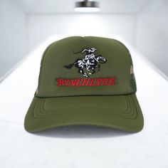 a green hat with the words winchester on it and a black horse embroidered on the front