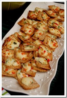 small crackers are arranged on a white platter