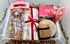 a gift box with flowers, candles and other items