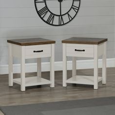 two white nightstand tables with wooden top in front of a large clock