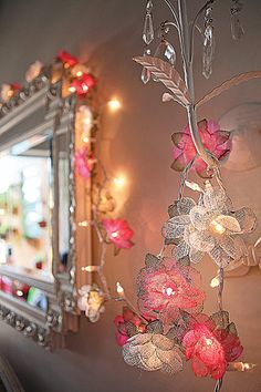 a mirror hanging from the side of a wall with flowers on it