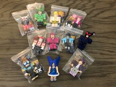 small toy figurines sitting in plastic bags on a wooden table with other toys