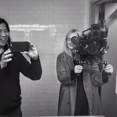 two women are standing in front of a mirror and one is holding up a camera