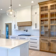 a large kitchen with white cabinets and marble counter tops