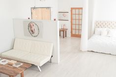 a white living room with a couch, coffee table and pictures on the wall above it