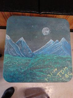 a chalk drawing of mountains and stars on a mouse pad with the words mountain written below it