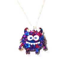 So you like silly monsters, glitter, statement pendant necklaces, and spooky whimsical things? We got you, fam! Designed for the young and young at heart, we're excited to bring you these handmade laser cut and laser engraved Silly Monsters that Milo's Marvelous Crafts has designed especially for you. These gorgeous sparkling Silly Monsters in Purple Chunky Glitter Glitter Acrylic Pendants are super fun with their big eyes, horns, and a goofy grin. Photos honestly don't do them justice. At 1.4 inches long, these Purple Glitter Silly Monsters are incredibly lightweight since they are made with Laser Cut Acrylics. Choose either 18 or 20 inches for your custom-made Gold-Plated or Silver-Plated Necklace Chain.  A perfect gift for the those that love Silly Monsters, Spooky Season, glitter, and Novelty Halloween Party Necklaces, Nickel-free Halloween Party Necklace, Purple Whimsical Necklace For Party, Whimsical Purple Necklace For Party, Unique Halloween Party Jewelry, Quirky Multicolor Jewelry For Gifts, Quirky Blue Jewelry For Gifts, Quirky Blue Jewelry For Gift, Whimsical Pendant Jewelry For Party