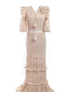 a crocheted dress with ruffles on the bottom and sleeves, in beige