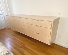 a white dresser sitting on top of a hard wood floor