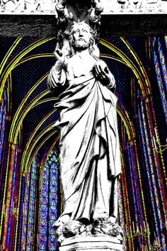 the statue of jesus is in front of an intricate stained glass window with arches and columns