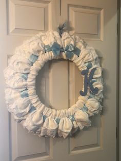 a wreath made out of diapers with the letter k on it hanging on a door