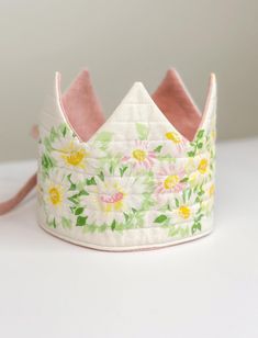 ♥♥ Introducing our Vintage Daisy & Linen Play Crown ♥♥ Make every day a royal adventure with our Vintage Daisy & Linen Play Crown. Perfect for birthdays, dress-up, or just sparking your little one's imagination, this crown is a delightful accessory for any occasion. * One Size Fits Most: Designed to comfortably fit heads measuring 17.9" and up, making it a versatile choice for many ages. * Reversible Design: Featuring quilted vintage daisy fabric on one side and pink linen on the other, this one Whimsical Tall Crown As Gift, First Birthday Flower Crown, Adjustable Structured Crown As A Gift, White Handmade Hats For Birthday, Whimsical Adjustable Crown As Gift, Adjustable Whimsical Crown As A Gift, Whimsical Tall Crown For Birthday, Handmade Adjustable Whimsical Crown, Whimsical Adjustable Handmade Crown