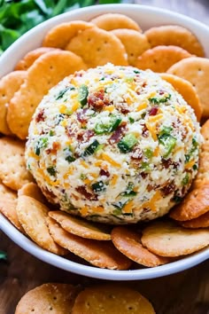 a cheese ball surrounded by crackers in a bowl