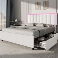 a white bed sitting in a bedroom next to a window with pink lights on it