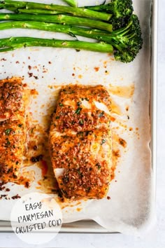 two fish fillets with parmesan and broccoli on a white plate