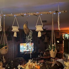 several hanging baskets with tassels on them in a living room area next to a television