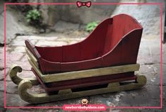 a red wooden sleigh sitting on top of a stone floor