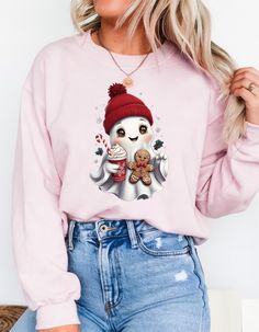 a woman wearing a pink sweater with a snowman and gingerbreads on it