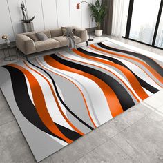 a modern living room with an orange, black and white area rug on the floor