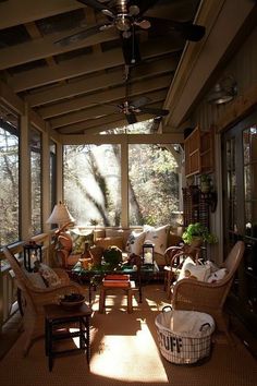 the sun shines through the windows into a screened porch with wicker furniture and lamps