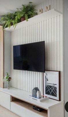 a flat screen tv sitting on top of a white entertainment center in a living room