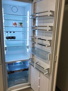 an open refrigerator with its door wide open and no ice maker on the bottom shelf