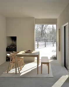 a dining room table and chairs in front of a sliding glass door that leads to a snowy yard