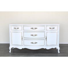 a white dresser with gold trim and drawers