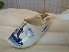 a blue and white porcelain pitcher sitting on top of a bed