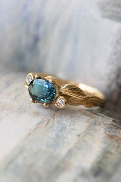 a gold ring with a blue stone and two diamonds