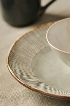 a white plate topped with an apple next to a cup