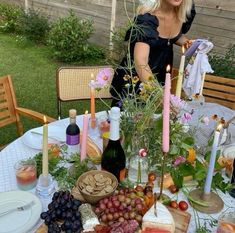 a woman standing in front of a table filled with food