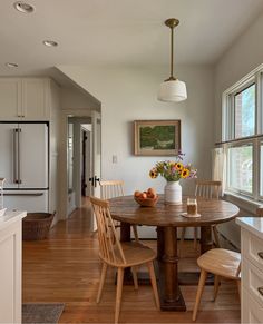 a kitchen with a table and chairs next to an island in the middle of the room