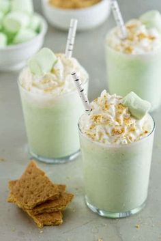 three glasses filled with green drink and topped with marshmallows, graham crackers and s'mores