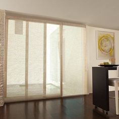 a living room with sliding glass doors and hard wood flooring