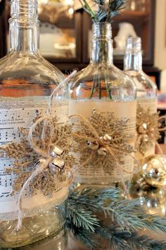 two bottles with christmas decorations in them sitting on a table