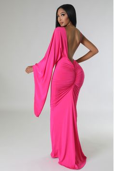 a woman in a long pink dress with her back turned to the camera and wearing an open