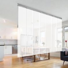 a living room filled with furniture next to a window covered in sheers and curtains