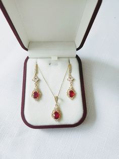 **All orders come with tracked shipping** ** Ready to ship in 1 business day** ** Shipping time to Canada and U.S: 2-5 business days** High quality champagne gold plated Gatsby style earrings and necklace set with red cubic zirconia stones surrounded by beautiful intricate filigree work and small round clear stones at the corners.  The chain is 1mm thick and 46cm long. It is easily adjustable to make it shorter to your desired length simply by pulling on the chain through the round gold bead. It Red Art Deco Jewelry For Formal Occasions, Red Art Deco Jewelry For Wedding, Elegant Ruby Jewelry Sets With Matching Earrings, Art Deco Ruby Jewelry As A Gift, Art Deco Ruby Jewelry Gift, Red Victorian Jewelry For Evening, Fine Jewelry Filigree Red Jewelry, Red Filigree Fine Jewelry, Ruby Necklaces With Matching Earrings For Gift