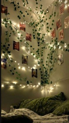 a bedroom decorated with lights and ivys on the wall, along with pictures hanging from the ceiling