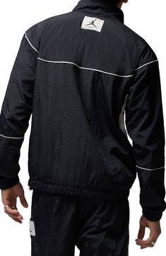 Constrast trim traces the sleek design of this lightweight warmup jacket crafted from a breathable nylon weave and outfitted with secure zip pockets. 27" length ( size Medium ) Stand collar Breathable construction allows ventilation of excess heat for cooling comfort Elastic cuffs and hem Mesh lining 100% nylon Machine wash, line dry Imported Nordstrom x Nike: A curated lifestyle destination where fashion is the ultimate sport Nylon Half-zip Sportswear Outerwear, Black Nylon Outerwear With Elastic Cuffs, Black Long Sleeve Track Jacket With Contrast Panels, Reflective Long Sleeve Track Jacket For Streetwear, Nylon Long Sleeve Windbreaker For Sports, Nylon Sports Windbreaker, Nylon Long Sleeve Track Jacket In Athleisure Style, Black Track Jacket With Contrast Panels For Fall, Sporty Long Sleeve Nylon Outerwear