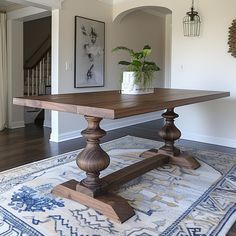 a large wooden table sitting on top of a rug