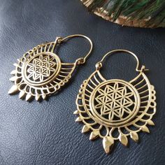 Openwork Hoop Earrings in Silver or Gold Brass. These Creoles are Elegantly Decorated with the Flower of Life Pattern Surrounded By A Circle. The Circle Of The Hoops Is Decorated With Spikes To Give These Earrings A More Ethnic Style. The Powerful Flower of Life Symbol Of Sacred Geometry Releases Good Waves. The Flower of Life Symbolizes Regeneration, Creation and Metamorphosis. She Represents the Cycle of Life. These Hoop Earrings are very elegant and they will illuminate your face. Timeless and Lightweight Creoles to Wear Everyday to Give an Ethnic Touch to Your Outfits. They are made from brass. Material: Brass Color: Silver or Gold Length: 5.7cm Width: 3.5cm Thickness: 0.2 cm Weight: 14 Gm The Pair Handmade Delivered in a Fabric Pouch Ideal for Gifting To offer or simply treat yourself Adjustable Teardrop Hoop Earrings For Festival, Handmade Brass Cartilage Earrings For Festival, Handmade Spiritual Gold Plug Earrings, Bohemian Small Hoop Plug Earrings, Brass Hoop Jewelry For Festivals, Bohemian Teardrop Brass Hoop Earrings, Spiritual Gold Hoop Earrings For Festivals, Artisan Metal Hoop Earrings For Festivals, Bohemian Handmade Earrings For Rituals