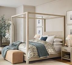 a bedroom with a four poster bed and pictures on the wall, along with two nightstands