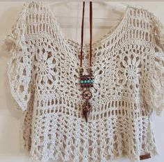 a crocheted top with beads hanging from it's neck and a leather cord